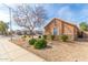 Suburban home with low maintenance desert landscaping, a mature tree, and a residential street at 12312 N 147Th Ln, Surprise, AZ 85379