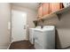 A laundry room featuring a washer and dryer, overhead cabinets and tile floors at 12312 N 147Th Ln, Surprise, AZ 85379