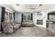 Cozy living room featuring a gray sofa set, modern fireplace, and large windows with natural light at 12312 N 147Th Ln, Surprise, AZ 85379