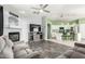 Open-concept living room with modern gray sofa set, fireplace, and view into the bright kitchen at 12312 N 147Th Ln, Surprise, AZ 85379