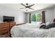 Well-lit main bedroom provides a ceiling fan, wood look floors and view of the backyard pool at 12312 N 147Th Ln, Surprise, AZ 85379