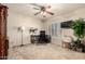 Bright bedroom featuring a ceiling fan, work space, and window with plantation shutters at 12809 W Evans Dr, El Mirage, AZ 85335