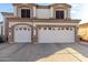 Close up on a three-car garage with white doors on a two-story home at 12809 W Evans Dr, El Mirage, AZ 85335