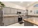 Modern kitchen with stainless steel appliances, granite countertops, and sleek gray cabinetry at 12809 W Evans Dr, El Mirage, AZ 85335