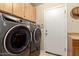 Modern laundry room featuring new washer and dryer, and door to the exterior at 12809 W Evans Dr, El Mirage, AZ 85335