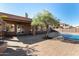 Beautiful backyard with a pool, covered patio, tree, and brick pavers perfect for outdoor living and entertaining at 1314 W Windsong Dr, Phoenix, AZ 85045