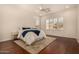 Light-filled bedroom with wood floors, a ceiling fan, and large windows with plantation shutters at 1314 W Windsong Dr, Phoenix, AZ 85045