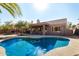 Inviting backyard pool with a covered patio, barbecue, and lush landscaping for ultimate relaxation and entertainment at 1314 W Windsong Dr, Phoenix, AZ 85045