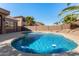 Sparkling backyard pool with a sun shelf, surrounded by lush greenery and a block fence for privacy at 1314 W Windsong Dr, Phoenix, AZ 85045