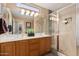 Bathroom featuring a double sink vanity, large mirror, and tiled shower with glass door at 1403 E Las Colinas Dr, Chandler, AZ 85249