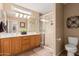 Bathroom featuring a double sink vanity, large mirror, and tiled shower with glass door at 1403 E Las Colinas Dr, Chandler, AZ 85249