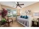 Neutral bedroom with decorative pillows on a day bed, shutters, ceiling fan, and tile flooring at 1403 E Las Colinas Dr, Chandler, AZ 85249