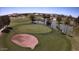 Aerial view of a pristine golf course with a sand trap and pond, surrounded by palm trees and green fairways at 1403 E Las Colinas Dr, Chandler, AZ 85249