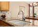 Kitchen sink features granite counters, stylish faucet and soap dispenser, and view into the eat-in kitchen at 1403 E Las Colinas Dr, Chandler, AZ 85249