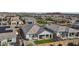 A high-angle shows an orderly neighborhood with desert surroundings, community tennis court, and solar panels at 14317 W Faye Way, Surprise, AZ 85387