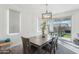 Inviting dining area with a rustic wooden table, stylish chandelier, and sliding glass doors to the backyard at 14317 W Faye Way, Surprise, AZ 85387