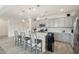 Modern kitchen with gray cabinets, quartz counters, stainless steel appliances, and an island with barstool seating at 14317 W Faye Way, Surprise, AZ 85387