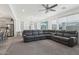 Open concept floor plan with comfortable gray sectional sofa connecting the living room to the dining area and kitchen at 14317 W Faye Way, Surprise, AZ 85387