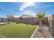 Expansive backyard with lush artificial turf, mature trees, and a privacy fence at 14325 W Faye Way, Surprise, AZ 85387