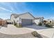 Side view of a single-story home showcasing a spacious driveway, desert landscaping, and gray garage door at 14325 W Faye Way, Surprise, AZ 85387