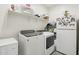 Well-organized laundry room with washer, dryer, storage shelves and a refrigerator at 14325 W Faye Way, Surprise, AZ 85387