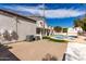 Backyard view with a sparkling pool, lush lawn, and a diving board, perfect for outdoor entertainment and relaxation at 14401 N 29Th St, Phoenix, AZ 85032