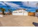 A three-car garage with white doors and a long driveway, providing ample parking space and curb appeal at 14401 N 29Th St, Phoenix, AZ 85032