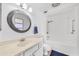 Bright bathroom featuring a round mirror and white cabinets and shower/tub combination at 15602 N Nicklaus Ln, Sun City, AZ 85351