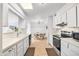 Efficient kitchen featuring white cabinets, laminate countertops, and seamlessly flowing into the adjacent dining area at 15602 N Nicklaus Ln, Sun City, AZ 85351