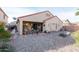 Desert backyard with rock landscaping, a covered patio with lights, and a seating area at 17632 W Voltaire St, Surprise, AZ 85388