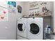 Functional laundry room featuring a side-by-side washer and dryer, plus ample storage shelf at 17632 W Voltaire St, Surprise, AZ 85388