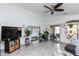 Spacious living area with lots of plants, a ceiling fan, a sliding door, and tiled flooring, providing comfort and style at 17632 W Voltaire St, Surprise, AZ 85388