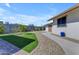 The backyard features a rock pathway, a lush artificial turf, mature citrus trees, and a view of the home's exterior at 1840 N Brighton Cir, Mesa, AZ 85207