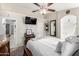 This bedroom features a ceiling fan, TV, dark wood dresser, and a queen size bed at 1847 E Milky Way, Gilbert, AZ 85295