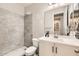 Well-lit bathroom showcasing a walk-in shower with stone surround and a modern white vanity at 18625 W Williams Rd, Surprise, AZ 85387