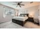 Serene bedroom with a dark wood bed frame, neutral tones, and a ceiling fan at 18625 W Williams Rd, Surprise, AZ 85387