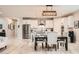 Open-concept kitchen and dining area with stainless steel appliances, white cabinets, and modern lighting at 18625 W Williams Rd, Surprise, AZ 85387