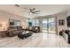 Bright living room featuring wood flooring, a ceiling fan, and sliding glass doors to the backyard at 18625 W Williams Rd, Surprise, AZ 85387