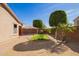 Spacious backyard with a small lawn, gravel, mature trees, and brick-lined walkway at 18637 W Fulton St, Goodyear, AZ 85338