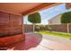 Backyard area featuring a paved patio, a wooden bench, a lawn, and manicured landscaping at 18637 W Fulton St, Goodyear, AZ 85338