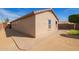 Exterior view of the property featuring brickwork, tan stucco, and a well-kept lawn and landscaping at 18637 W Fulton St, Goodyear, AZ 85338