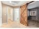 Hallway featuring an open view into the bedroom, showing a rustic sliding barn door at 18637 W Fulton St, Goodyear, AZ 85338