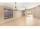 Spacious living room featuring neutral paint, tile flooring, a modern chandelier, and abundant natural light at 18637 W Fulton St, Goodyear, AZ 85338