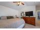 Bedroom featuring a ceiling fan, large dresser with TV, and view to the ensuite bathroom at 1899 W Prospector Way, San Tan Valley, AZ 85144