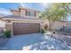 Two-story home featuring a two-car garage and low maintenance front yard landscaping at 1899 W Prospector Way, San Tan Valley, AZ 85144