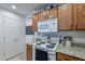 Traditional kitchen featuring oak cabinets, granite countertops, and modern white appliances at 1899 W Prospector Way, San Tan Valley, AZ 85144