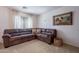 Living room featuring a cozy, oversized brown sectional sofa and natural light at 1899 W Prospector Way, San Tan Valley, AZ 85144