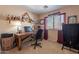 Comfortable home office space with a wood desk and natural light at 1899 W Prospector Way, San Tan Valley, AZ 85144