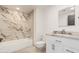 Modern bathroom showcasing stylish marble tile, a tub, and a granite-topped vanity at 19817 N Ponderosa Cir, Sun City, AZ 85373