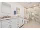 Renovated bathroom with double sinks, quartz countertops, and glass shower at 19817 N Ponderosa Cir, Sun City, AZ 85373